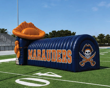 A large inflatable football field tunnel with 'MARAUDERS' in orange lettering and a pirate skull logo, set on a green turf field under a blue sky.